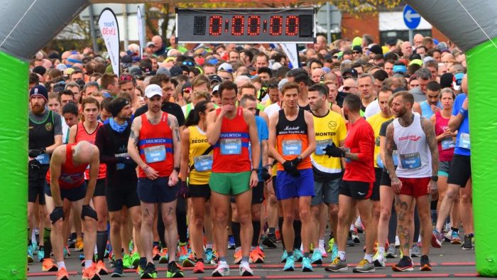 runners gathered at the marathon starting line under the timer