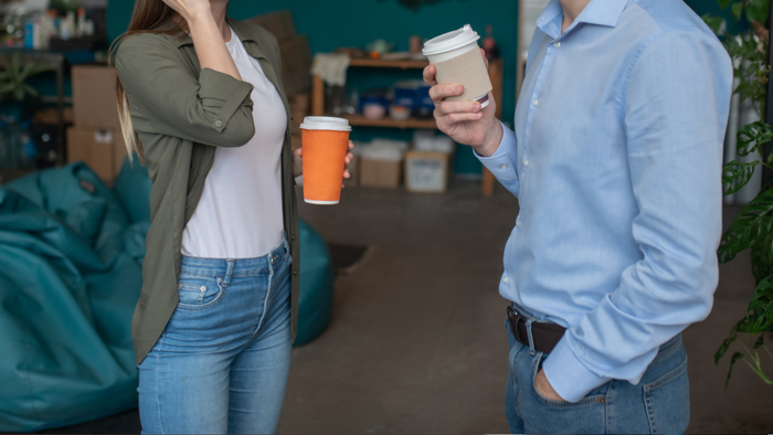 Two individuals engaging in a casual conversation at a coffee shop