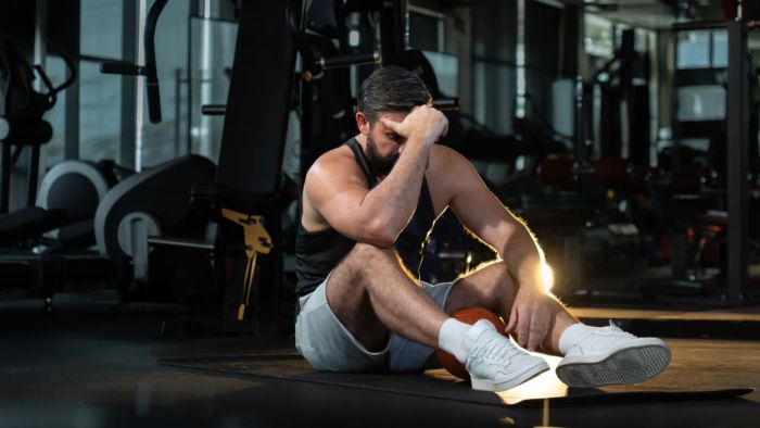 A puzzled man standing in a gym