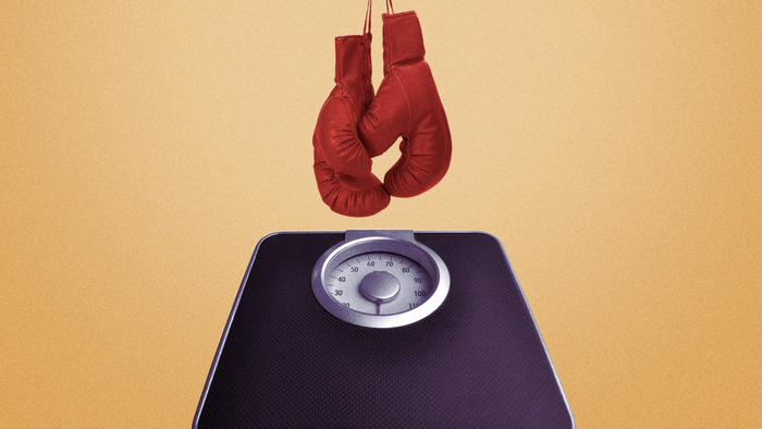 An image showing boxing gloves hanging above a bathroom scale