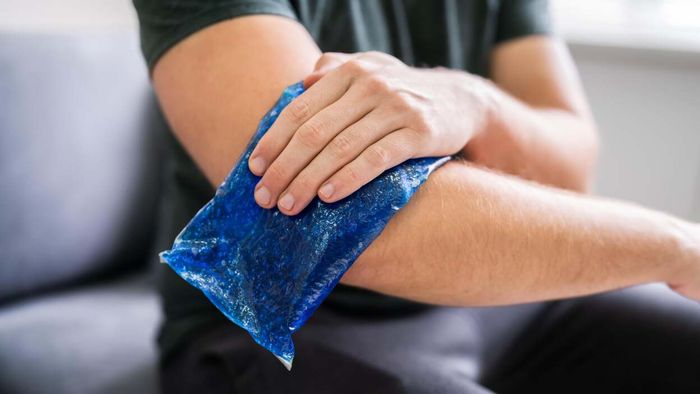 A person applying an ice pack to their arm