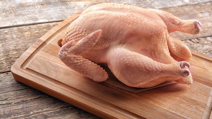 Raw turkey resting on a cutting board.