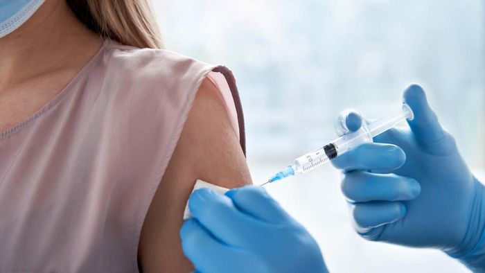 A woman receiving a vaccine in her upper arm