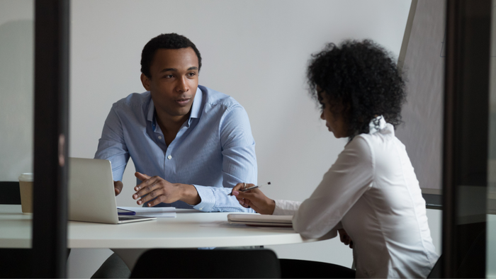 A man and a woman having a conversation at a table