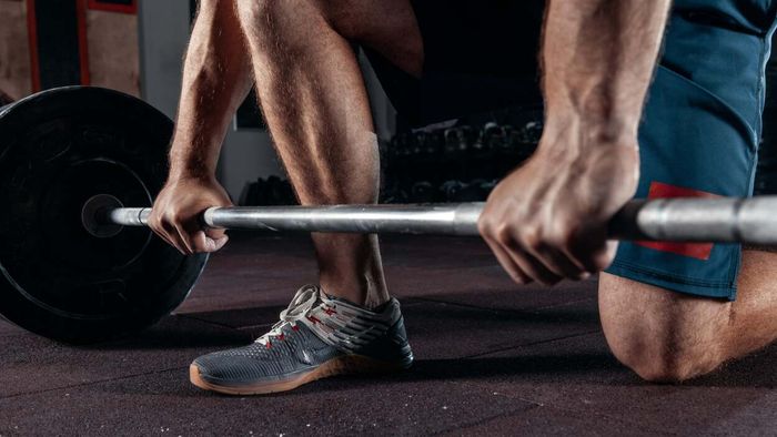 A person preparing for a barbell lift, focusing on their hands.