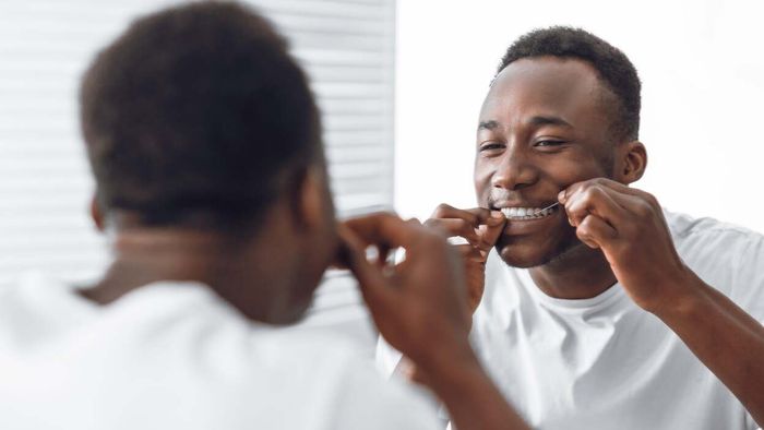 A person flossing (a habit many of us wish to establish!).