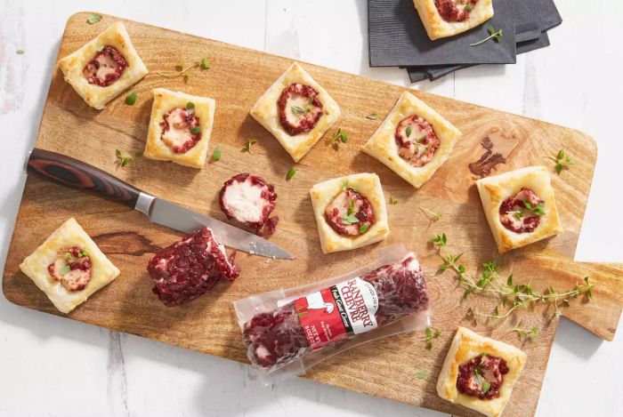 Trader Joe's Cranberry Chevre Goat Cheese beautifully displayed on puff pastry atop a cutting board.