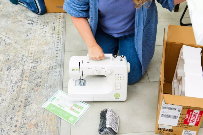 A person lifting the Baby Lock Zest Sewing Machine by its handle.