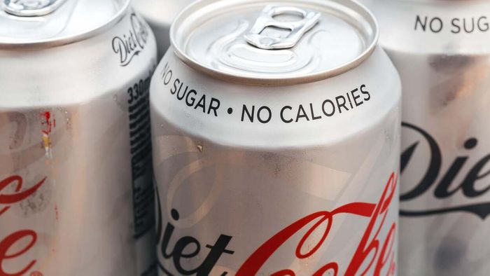 a detailed view of multiple Diet Coke cans featuring the text 'no sugar, no calories' on their lids