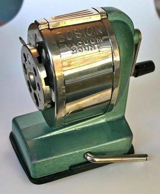 A classic Boston vacuum mount pencil sharpener featuring a sturdy metal casing and a manual handle for sharpening.