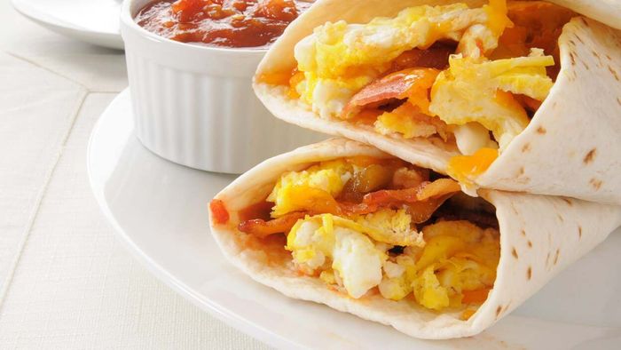 Make your own breakfast burritos by filling a tortilla with eggs and veggies, accompanied by a small serving of red salsa on the side