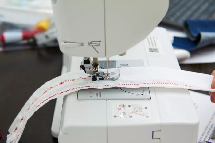 Close-up of an individual stitching various thread patterns with the Brother XR9550 Sewing Machine.