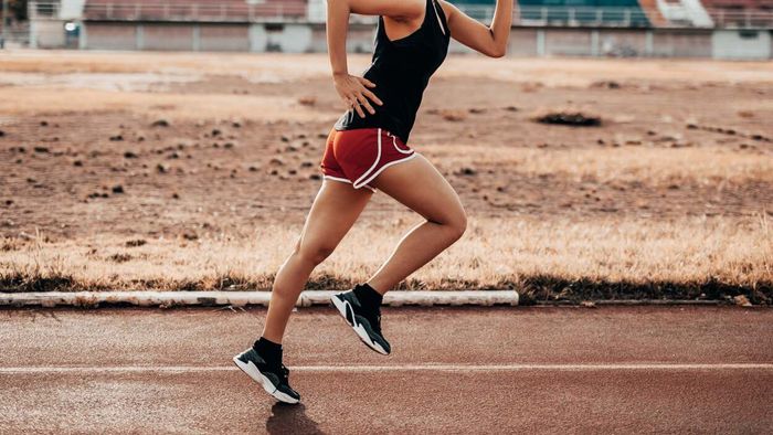 A female runner mid-stride on a track
