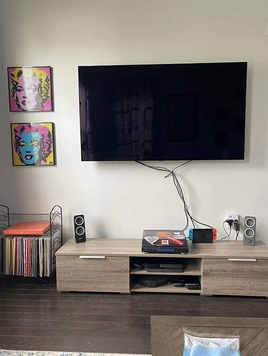 A reviewer’s TV stand resting directly on the floor, with no legs or elevation.