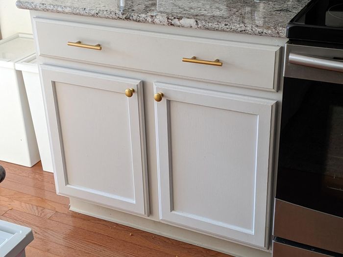 A white cabinet with stylish brass pulls for a modern touch.