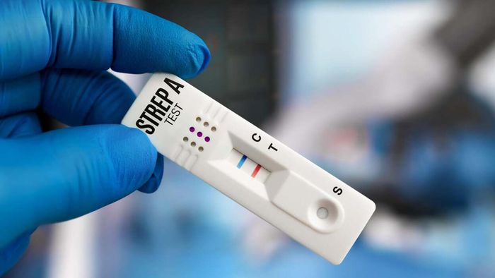 A physician holding a rapid test for Group A strep throat.