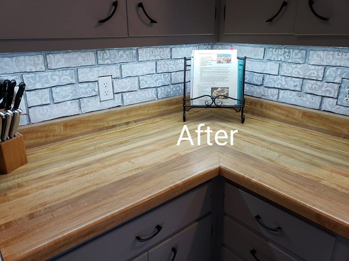 The same reviewer’s after photo showing their cabinets illuminated with soft white lighting.