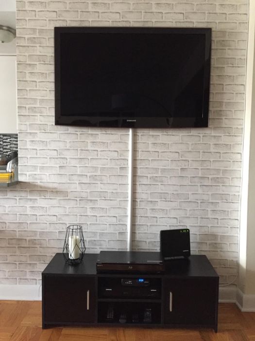 After: The same TV, now with a cord cover neatly hiding the cables.