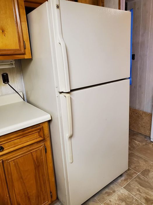 On the left, a white fridge next to a wooden cabinet.