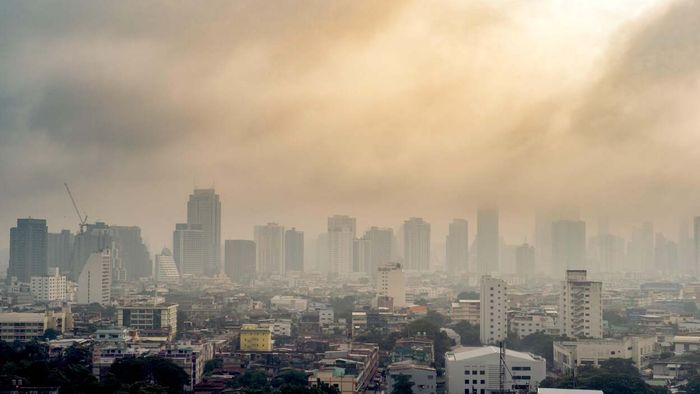 A city skyline vanishing into the haze of smoke from wildfires