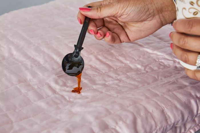 Close-up of a person accidentally spilling coffee on the Gravity Cooling Weighted Blanket during testing