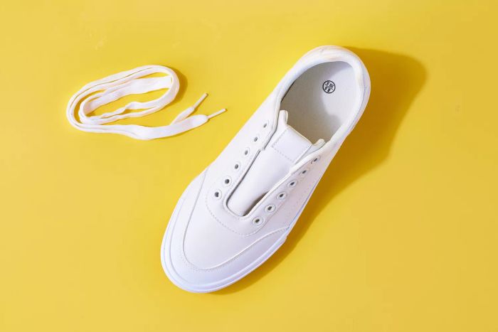 Shoelaces and a white leather shoe without laces