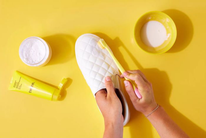 Toothbrush cleaning the side of a white leather shoe