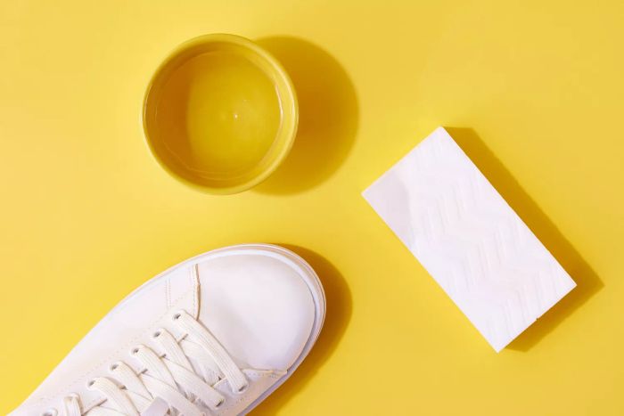 Magic eraser soaked in water for cleaning white leather shoes