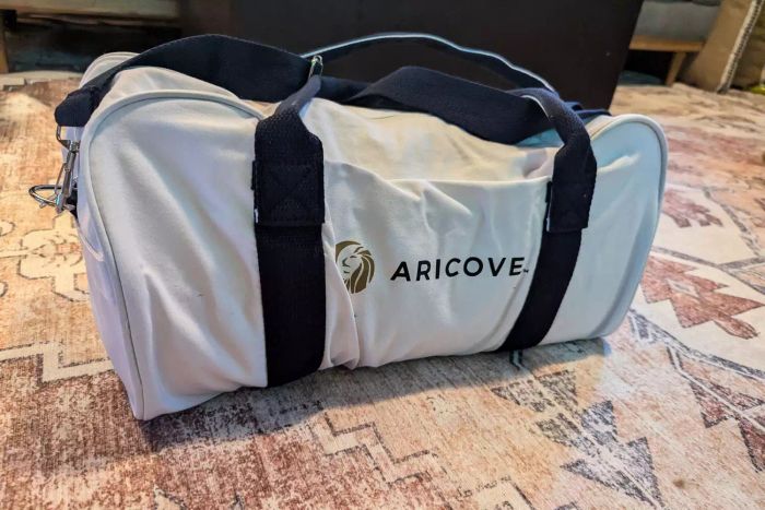 The Aricove Cooling Weighted Blanket stored in its carrying case on the floor