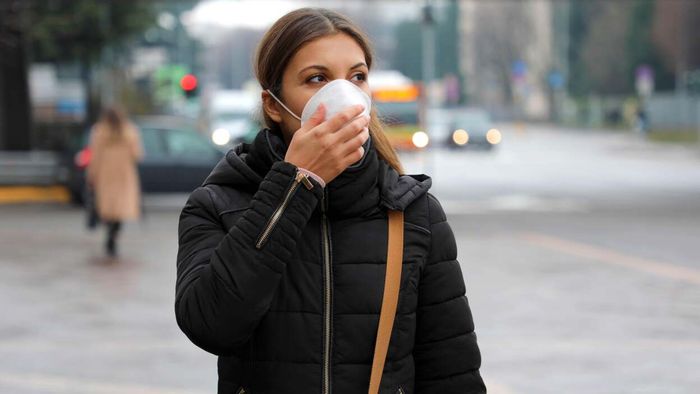 A woman outdoors wearing a COVID-19 mask