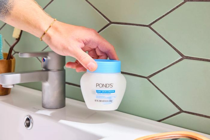 A person holding the Pond's Dry Skin Cream Facial Moisturizer