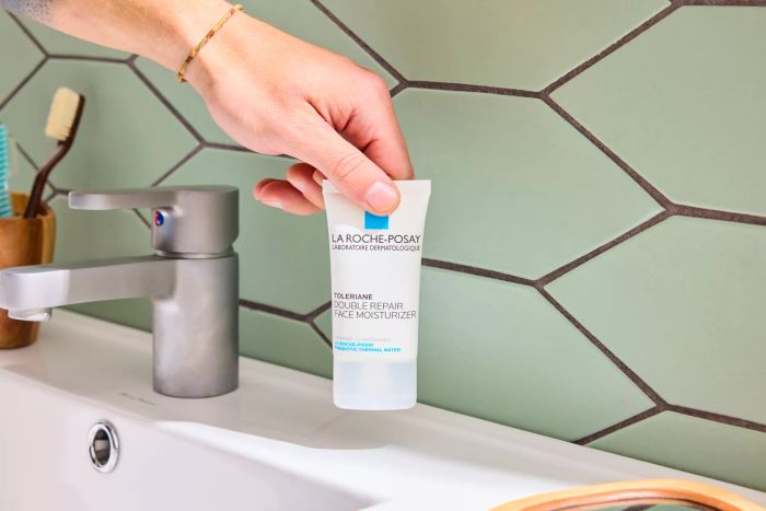 A person holding the La Roche-Posay Toleriane Double Repair Face Moisturizer