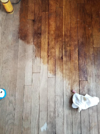 A reviewer’s photo of a worn wood floor, with half restored to its original shine thanks to the polish