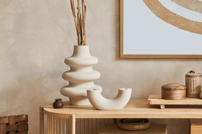 Elegant beige vases displayed on a wooden surface in a living space
