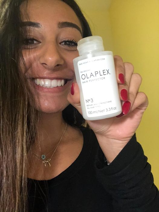 A happy reviewer showcasing Olaplex with a bright smile