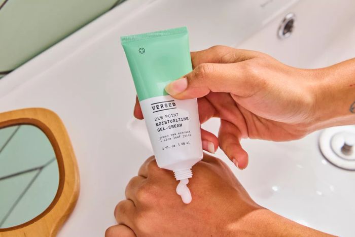 A person squeezing the Versed Dew Point Moisturizing Gel-Cream onto the back of their hand