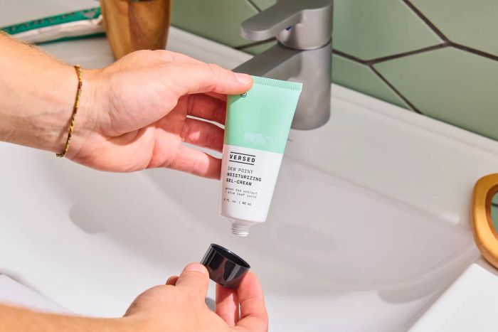 A person holding the lid and tube of the Versed Dew Point Moisturizing Gel-Cream