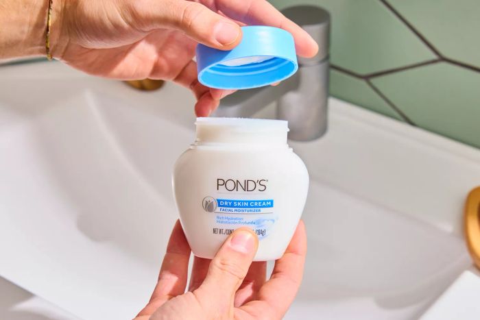 A person opening the Pond's Dry Skin Cream Facial Moisturizer