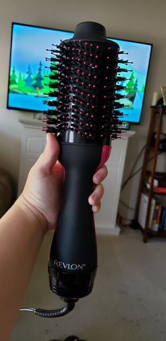 A reviewer holding the Revlon One-Step Dryer Brush