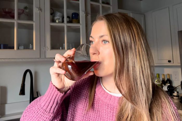 A person enjoying a beverage from a Libbey Polaris 16-Piece Tumbler and Rocks Glass Set glass