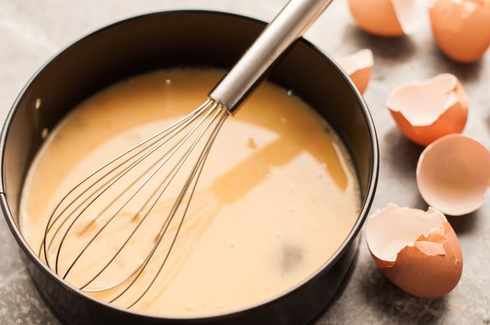 Beaten eggs in a pan, ready to be scrambled.