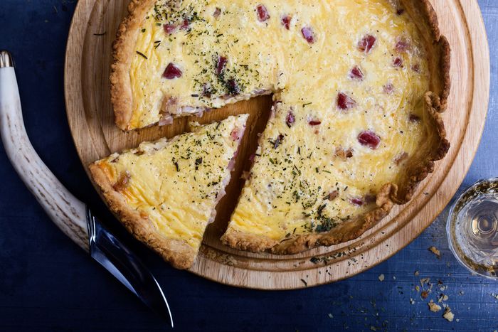 A freshly baked quiche sliced into portions.