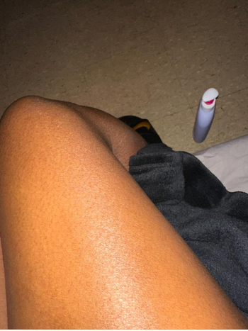 A person's leg with moisturizer applied