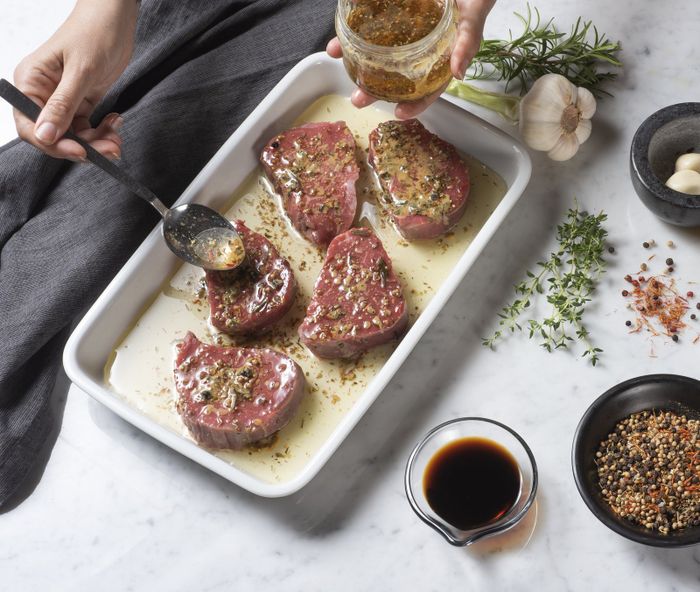 A woman preparing a meat marinade.