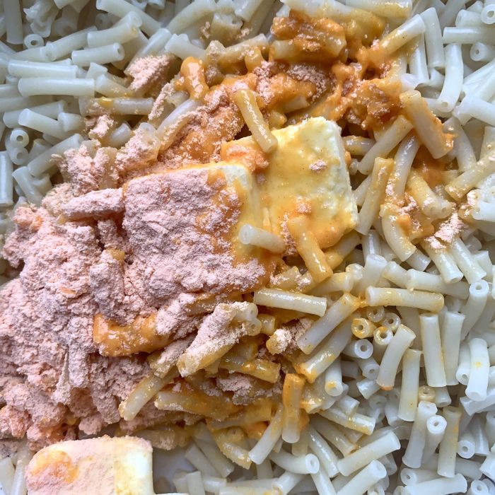 Preparing boxed mac 'n' cheese with butter and cheese powder.