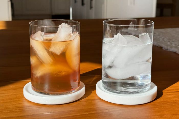 Two Made In Drinking Glasses placed on coasters atop a wooden table