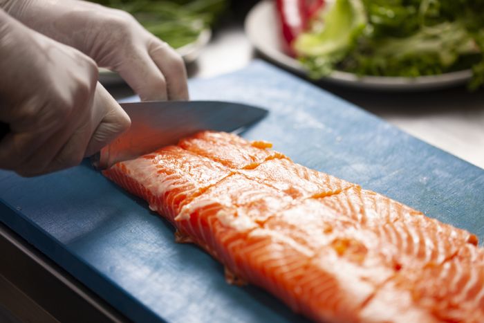 A person preparing salmon fillets.