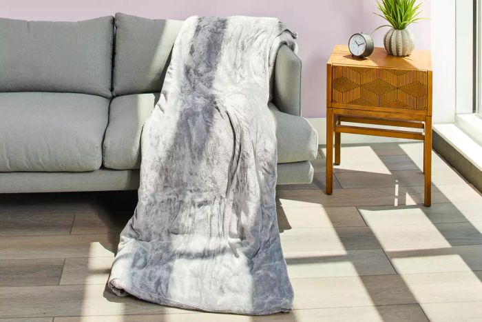 Threshold Microplush Weighted Blanket placed on a sofa beside a wooden side table