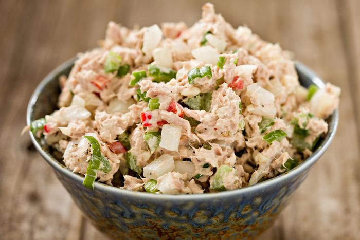 A blue ceramic bowl filled with freshly prepared tuna salad.