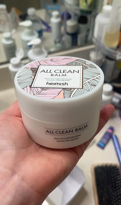 A reviewer holding the jar of Heimish cleansing balm